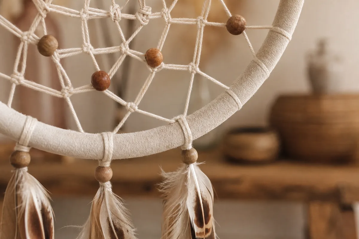 Détail d&rsquo;un attrape-rêves avec perles de bois serties et plumes solidement fixées, vu de près